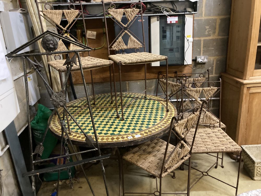 An iron framed circular tiled top table, a set of six iron framed chairs, with rope work seats and a wrought iron easel, table 128 diam